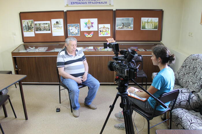 Tanya interviewing Efim Veprinskiy with camera on tripod 