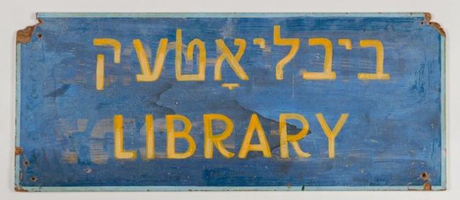 Blue sign with yellow text in Yiddish and English